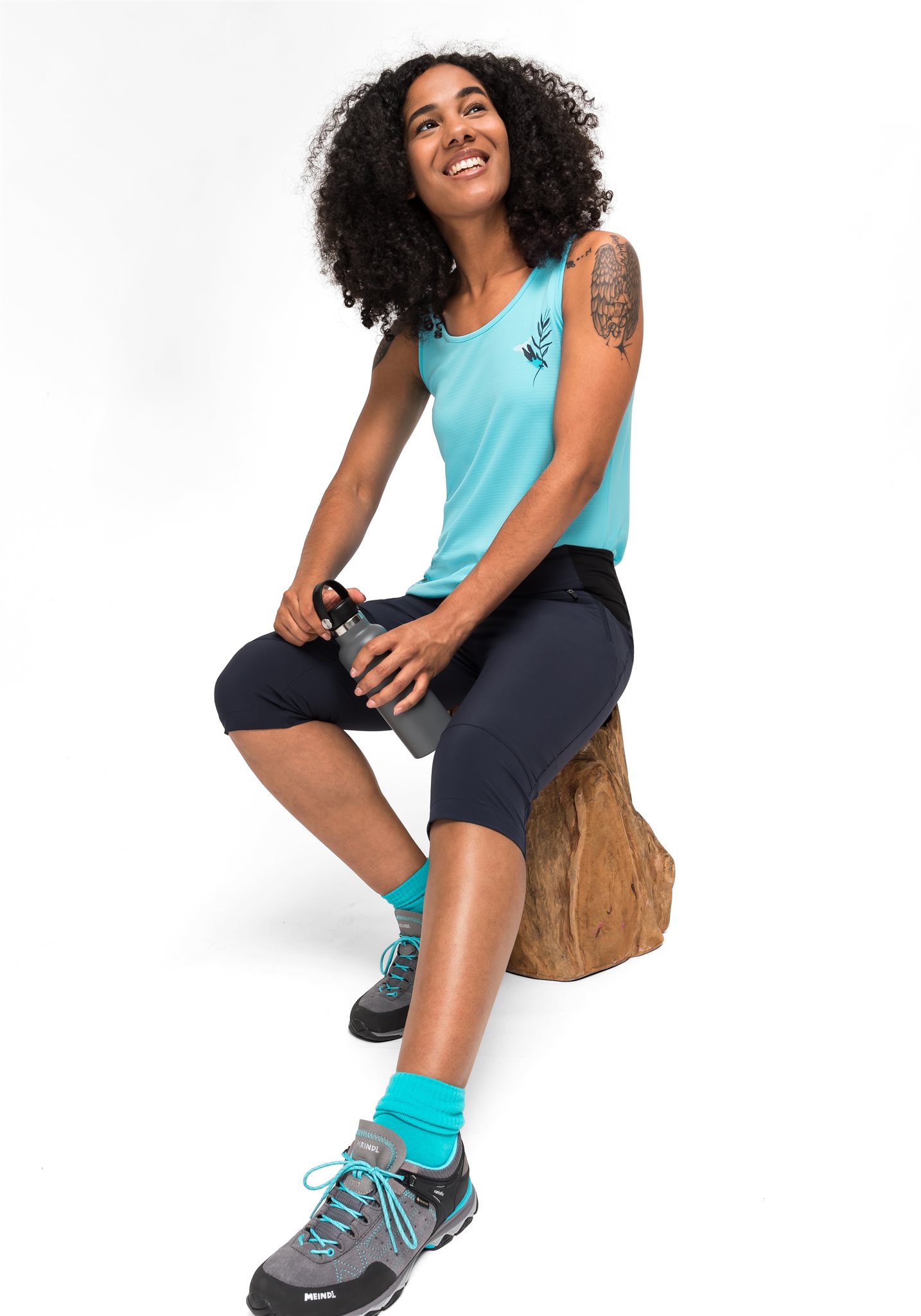 Vrouw poseert in Maier outfit op een witte achtergrond.