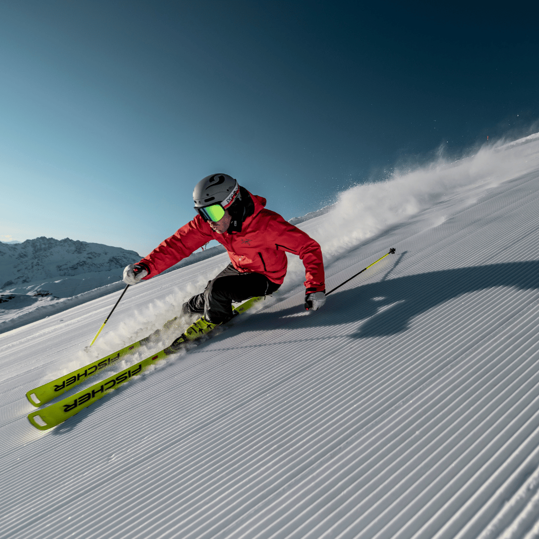 Man skiet naar beneden van piste met fischer ski's aan.